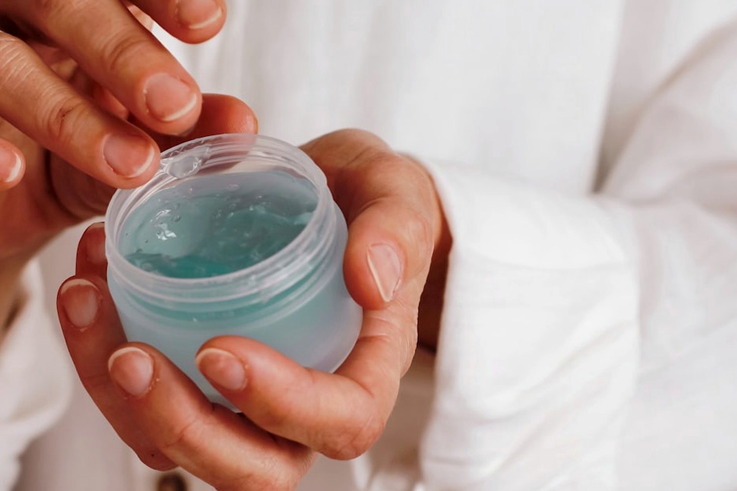 Hands holding skincare product for Best daily SPF products for different skin types in the UK.