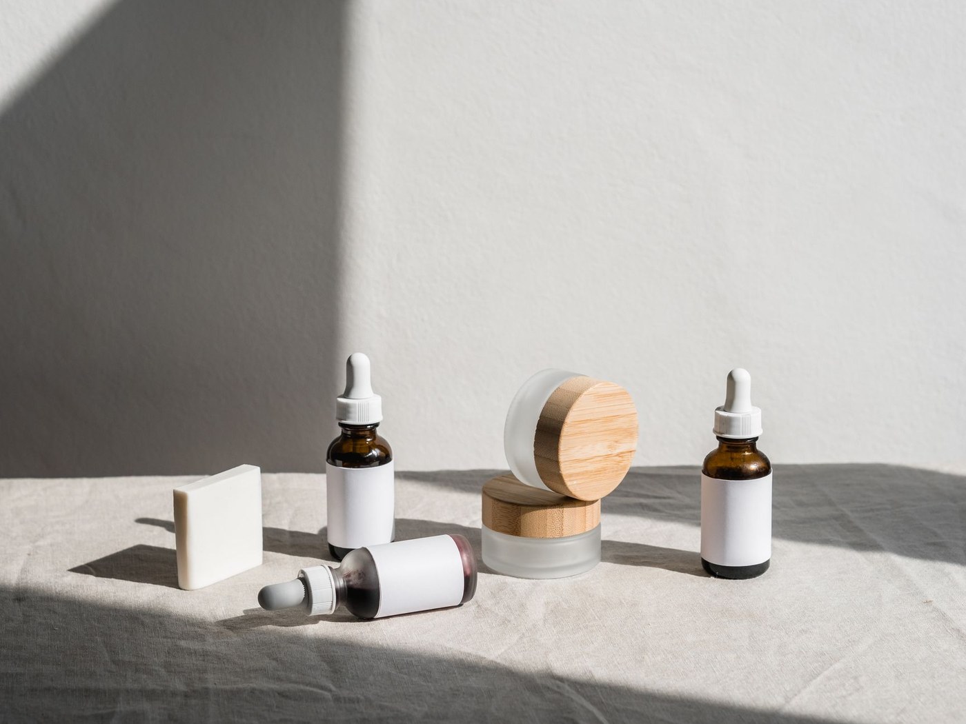 Dropper bottles and skincare jars arranged to compare fluid serum textures