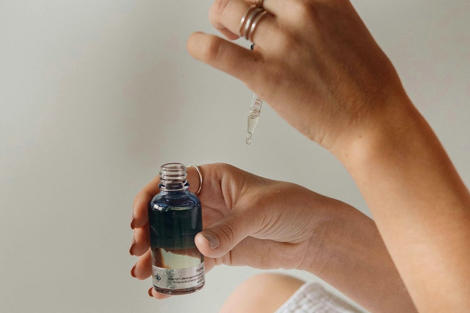 Hands holding skincare product for Invisible sunscreen for darker skin tones.