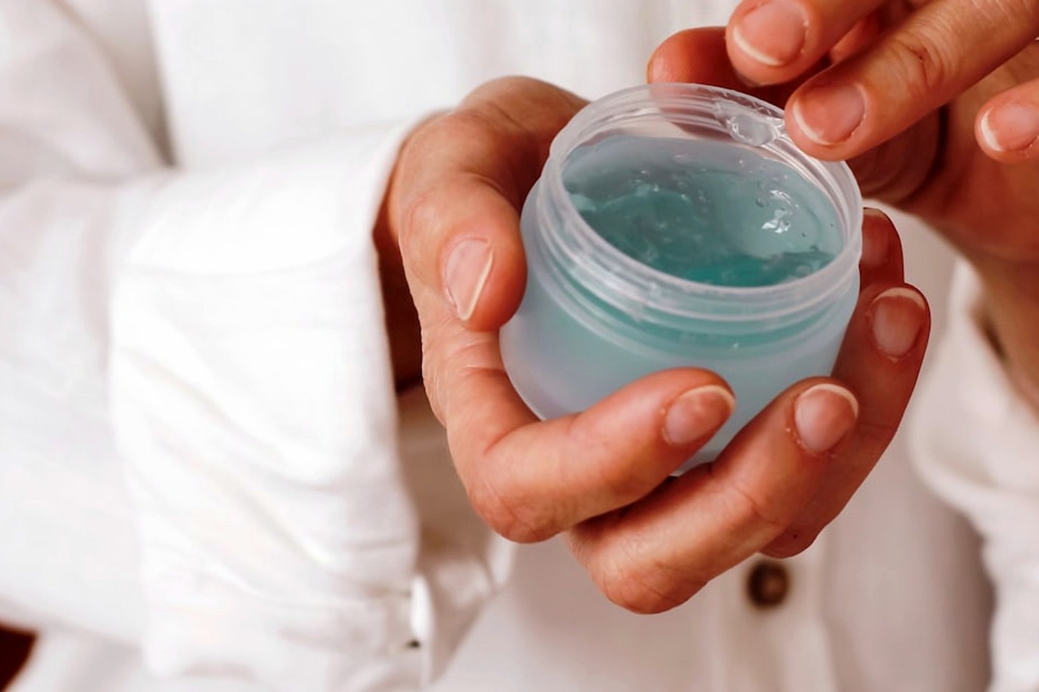 Hands holding skincare product for Invisible sunscreen for darker skin tones.