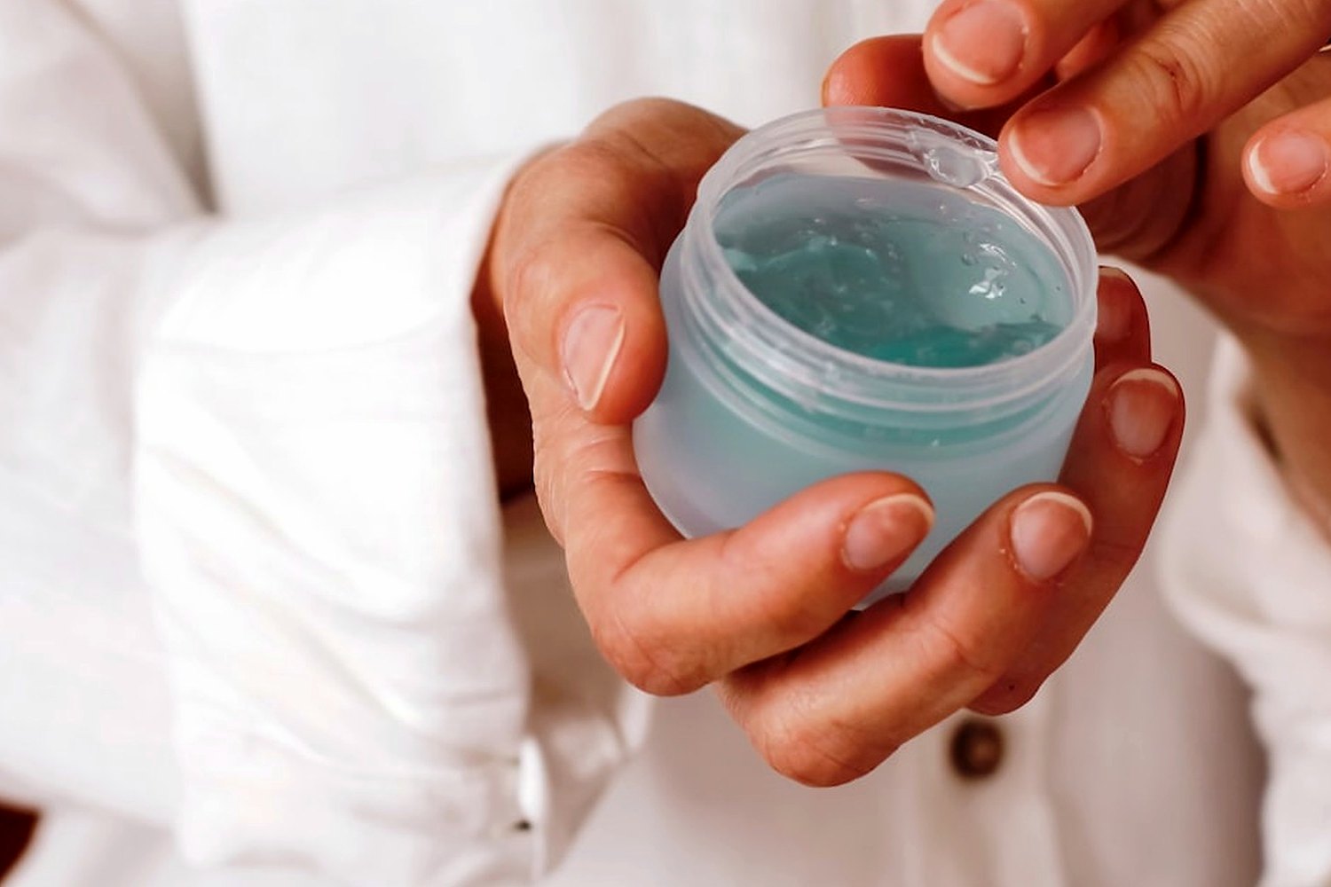 Hands holding skincare product for Matte sunscreen without a chalky finish.