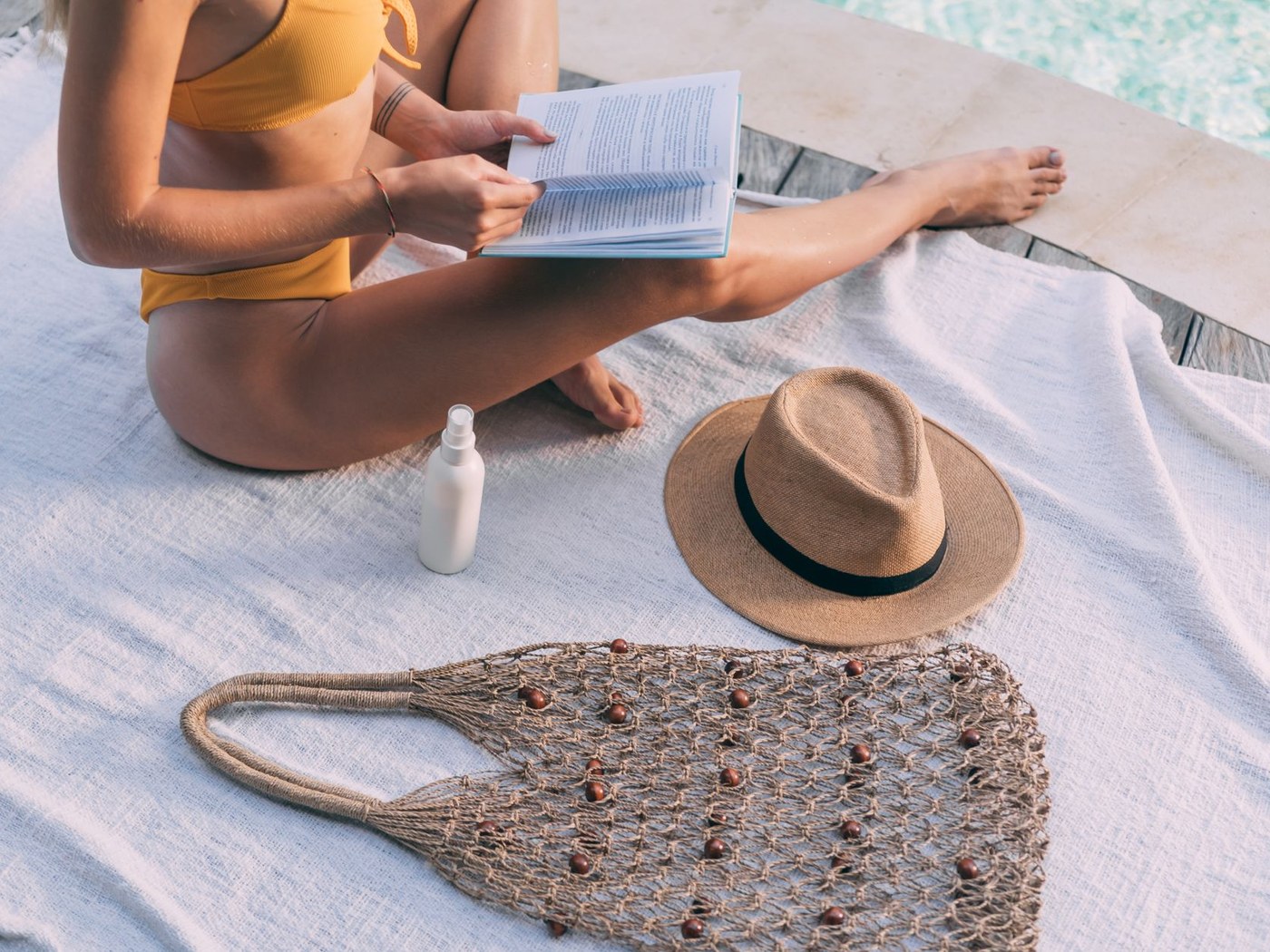 Sunscreen, hat and towel prepared for an outdoor day after a separate self-tan routine