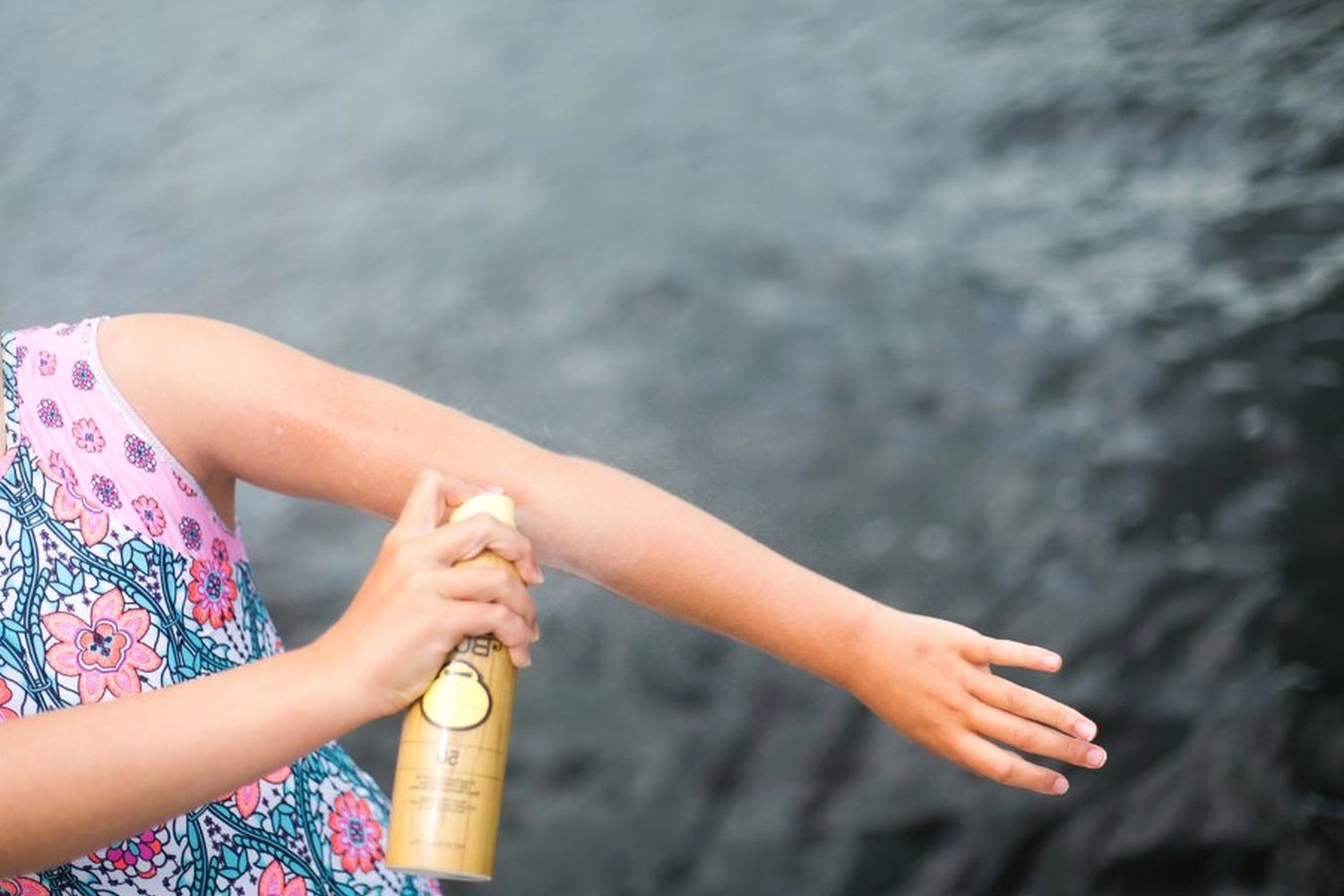 Sunscreen being applied to skin for Spray sunscreen.