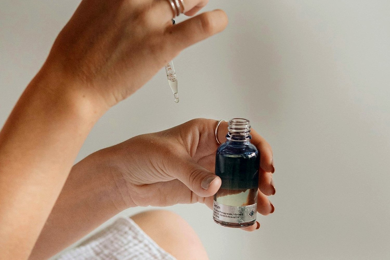 Hands holding skincare product for How to stop sunscreen pilling under makeup.