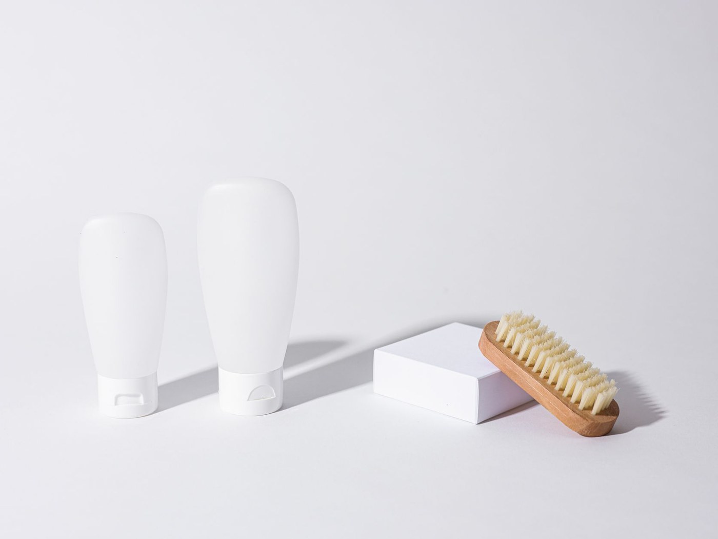 Two unbranded sunscreen tubes compared under neutral light with batch codes and seals visible