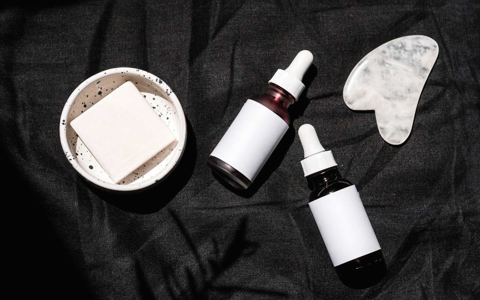 Dropper bottles and skincare tools arranged to illustrate fluid sunscreen texture